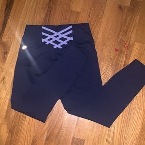 Fabletics Dark Navy Blue stretch leggings with purple stretch bands in back